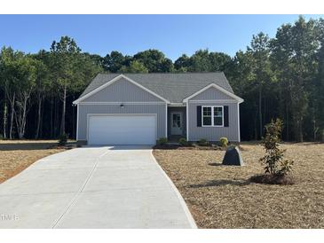 Charming single-story home with a well-manicured lawn and attached garage with a concrete driveway at 9254 Turkey Way, Middlesex, NC 27557