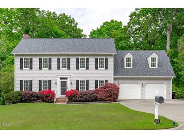Charming two-story home with a well-manicured lawn, beautiful flowers, and a two-car garage at 1007 Wellstone Cir, Apex, NC 27502
