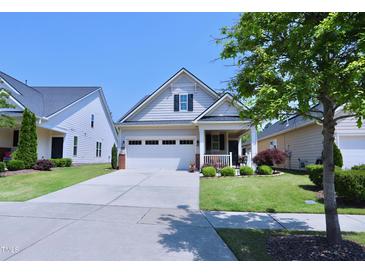Charming home featuring a two-car garage, lovely front porch, and well-manicured lawn at 1033 Cuthbert Ln, Durham, NC 27703