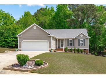 Charming home with a manicured lawn, lovely landscaping, and an attached two-car garage at 108 Christy Circle Ln, Clayton, NC 27520
