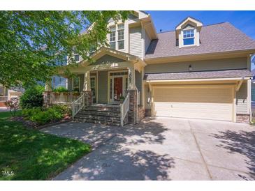 Charming home featuring a well-maintained front yard, covered porch, and attached two-car garage at 1097 Trentini Ave, Wake Forest, NC 27587