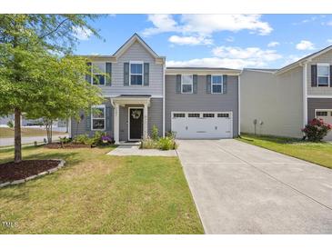 Charming two-story home with a well-manicured lawn and attached two-car garage at 1303 Bent Willow Dr, Durham, NC 27704
