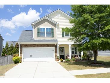 Charming two-story home with a well-manicured lawn, a two car garage and a welcoming front porch at 1940 Dunfield Dr, Fuquay Varina, NC 27526