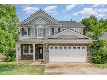 Charming two-story home with stone accents, shingle siding, attached two-car garage, and beautifully maintained landscaping at 196 Norwich Dr, Clayton, NC 27520