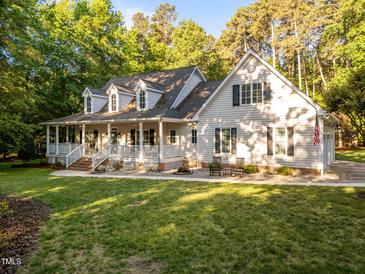 Charming two-story home featuring a large front porch, well-maintained lawn, and lush landscaping at 2616 Dockery Ln, Raleigh, NC 27606