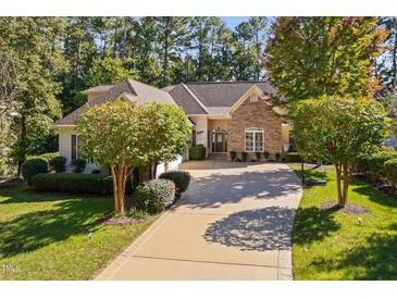 Charming single-story home featuring stone accents, a well-manicured lawn, and a long driveway at 39 Forked Pine Ct, Chapel Hill, NC 27517