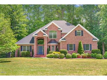 Stately brick home featuring a manicured lawn and mature landscaping at 412 Bowen Rd, Rougemont, NC 27572