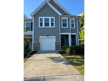 Charming townhome featuring stone accents, a one-car garage, and a welcoming front entrance at 5122 Jessip St, Morrisville, NC 27560
