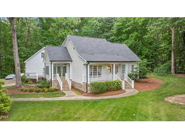 Charming, bright white cottage-style home with a welcoming front porch and lush green lawn at 5241 Mill Dam Rd, Wake Forest, NC 27587