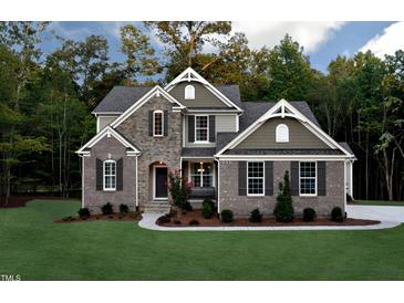 Beautiful two-story home with brick and stone exterior, complemented by a lush green lawn and mature trees at , Wake Forest, NC 27587