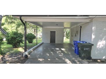 Covered carport featuring brick walls and concrete floor, offering practical parking and shelter at 626 S Hoover Rd, Durham, NC 27703