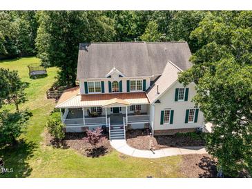 Aerial view of a two-story home featuring a wrap-around porch and green shutters surrounded by mature trees at 101 Rainbow Dr, Carrboro, NC 27510
