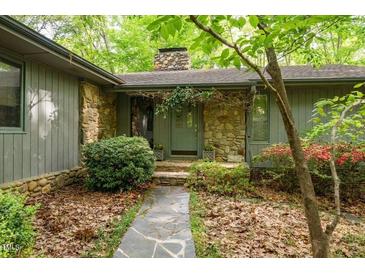 Charming stone and siding home with a stone walkway leading to the covered front entrance at 11009 Eaglerock Dr, Raleigh, NC 27613