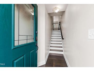 Inviting entryway with beautiful teal front door and staircase leading to the upper level of the home at 1101 Boxcar Way, Apex, NC 27502