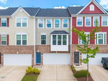 Charming multi-colored brick townhomes featuring attached garages and well-maintained landscaping at 114 Cross Country Way, Durham, NC 27703