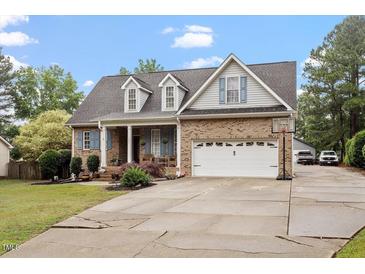 Charming brick home featuring dormer windows, shutters, attached garage with basketball hoop, and well-maintained landscaping at 151 Donnibrook, Fuquay Varina, NC 27526