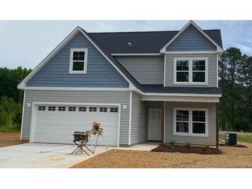 Charming two-story home with blue and gray siding, a two-car garage, and freshly laid straw at 160 Tupelo Dr, Spring Hope, NC 27882