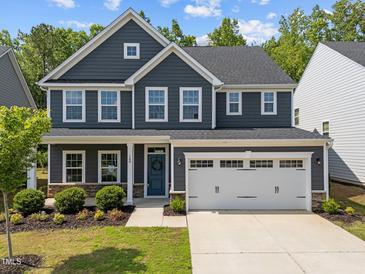 Charming two-story home featuring a two-car garage, landscaped yard, and inviting blue front door at 168 Amber Acorn Ave, Raleigh, NC 27603