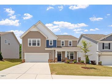 Charming two-story home with a two-car garage, well-maintained lawn, and inviting front porch at 170 Creekhaven Dr, Angier, NC 27501