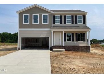 Two-story home featuring an attached garage, black window shutters, and a covered front entryway at 171 Alice Trace Place, Angier, NC 27501