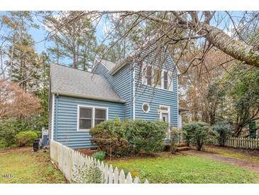 Charming two-story home featuring blue siding and a well-maintained front yard with a white picket fence at 1725 Briarforest Pl, Raleigh, NC 27615