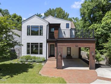 Beautiful modern home boasts a stylish white and wood exterior and a red brick driveway at 1820 Park Dr, Raleigh, NC 27605