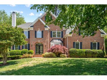 Charming brick two-story home with manicured lawn, arched entry, black shutters, and mature landscaping at 206 Glebe Way, Cary, NC 27519