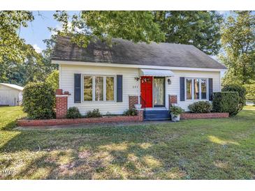 Charming one-story home with a bright red door, tidy landscaping and mature shade trees at 251 Charles Riddle Rd, Sanford, NC 27330