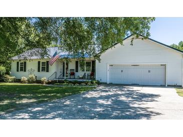 Charming home featuring a two-car garage, classic white siding, and a well-manicured front yard at 2717 Jack Rd, Clayton, NC 27520