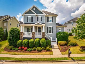 Charming two-story home with a welcoming front porch, beautiful landscaping, and a well-manicured lawn at 281 N Serenity Hill Cir, Chapel Hill, NC 27516