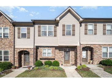 Charming townhome featuring a stone and siding facade, complemented by manicured landscaping and inviting entrances at 3945 Amelia Park Dr, Raleigh, NC 27606