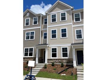 New townhome shows a charming exterior with stone accents and a welcoming entrance at 4002 Silver Oak Ln, Durham, NC 27703