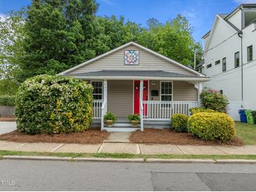 Charming bungalow with a cozy front porch, bright red door, and well-maintained landscaping at 401 Haywood St, Raleigh, NC 27601