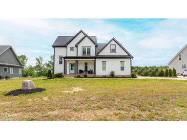 Charming two-story home with a well-manicured lawn and welcoming front porch at 474 Pine Ridge Rd, Zebulon, NC 27597