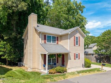 Charming two-story home features red shutters, a chimney, and a cozy front porch seating area at 504 High Ridge Dr, Durham, NC 27707