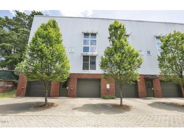 Modern townhome featuring metal siding, brick accents, individual garages and landscaped trees at 506 N Mangum St # 402, Durham, NC 27701