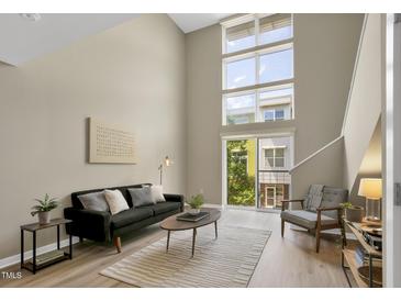 Bright living room boasts soaring windows, neutral color palette, and an open and airy feel at 506 N Mangum St # 402, Durham, NC 27701