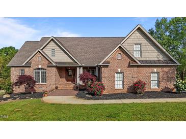 Beautiful brick home with manicured lawn and landscaped flower beds, exuding curb appeal at 5250 Sartin Rd, Burlington, NC 27217