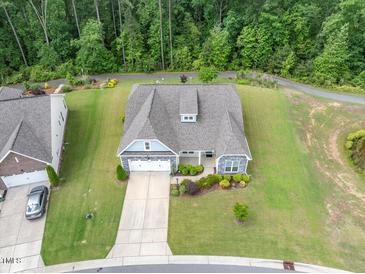 An aerial view of a home featuring beautiful landscaping, a two car garage, and mature tree coverage at 704 Long Lake Dr, Fuquay Varina, NC 27526