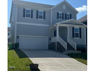 Charming two-story home with light gray siding, a two-car garage, and manicured front lawn at 712 Emmer St, Rolesville, NC 27571