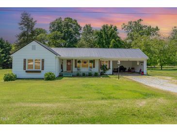 Charming single-Gathering home featuring a welcoming front porch and attached carport with a metal roof at 80 Lewis Moody Rd, Bear Creek, NC 27207