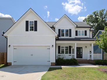 Charming two-story home featuring a two-car garage, black shutters, and a welcoming front porch at 808 Trinity Park Dr, Wake Forest, NC 27587