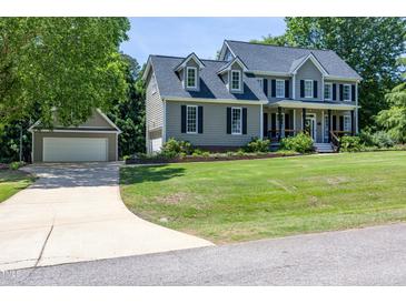 Charming two-story home with mature trees, a detached garage, and a beautifully manicured lawn at 8517 Falkirk Ridge Ct, Wake Forest, NC 27587