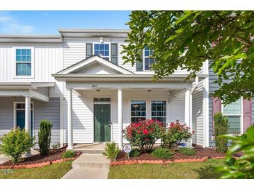Charming townhome exterior with a covered porch, green door, and well-manicured landscaping at 1027 Myers Point Dr, Morrisville, NC 27560