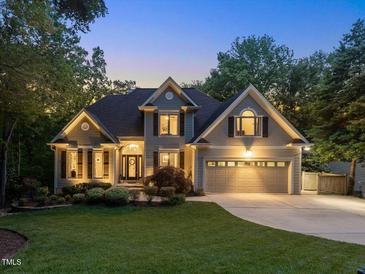 Charming two-story home with mature trees, a manicured lawn, and a two-car garage at 105 Highlands Lake Dr, Cary, NC 27518
