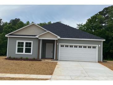 Charming one-story home with a two-car garage and a well-manicured lawn at 161 Tupelo Dr, Spring Hope, NC 27882