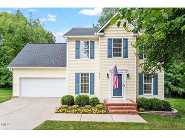 Charming two-story home featuring blue shutters, a well-manicured lawn, and an attached two-car garage at 1614 Finnsbury Dr, Burlington, NC 27217