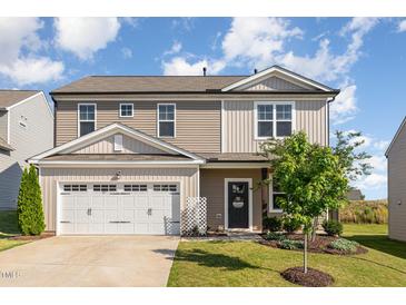 Two-story home featuring a two-car garage, landscaped yard, and charming front entrance with a 'Welcome' sign at 19 Cecina Ct, Clayton, NC 27527