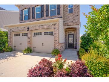 Beautiful two-story brick home featuring a two-car garage, black shutters, and well manicured landscaping at 1904 Birdhouse Ln, Wake Forest, NC 27587