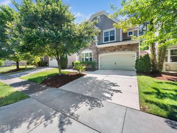 Charming home featuring a stone facade, two-car garage, and mature trees enhancing curb appeal at 205 Hammond Wood Pl, Morrisville, NC 27560